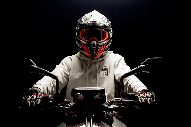 A motorcycle rider sitting on the bike wearing a good looking helmet.